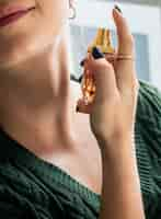 Free photo caucasian woman applying perfume to her neck