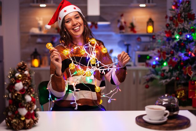 Caucasian woman decorating christmas tree with lights