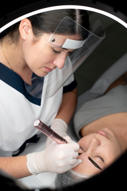 Free photo caucasian woman going through a microblading treatment