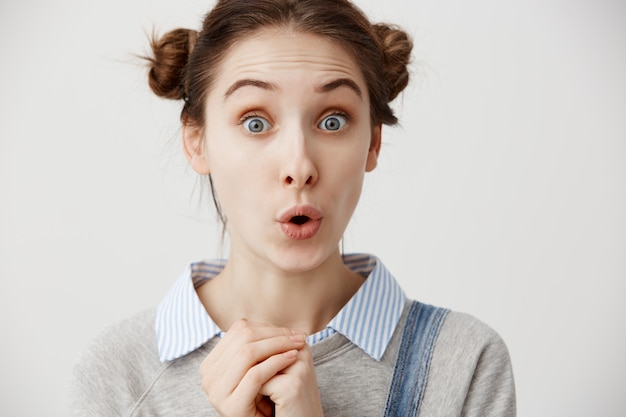 Caucasian woman looking astonished holding fists clenched. Attractive female office worker wondering being surprised while gossiping or having interesting conversation with her coworker. Closeup