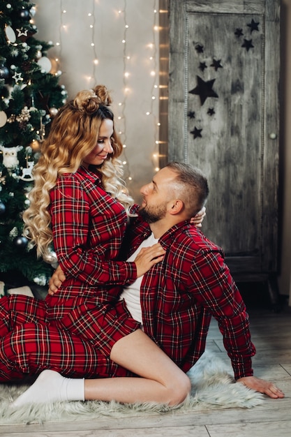 Кавказская женщина и мужчина вместе отдыхают на полу в гостиной в рождественской атмосфере.