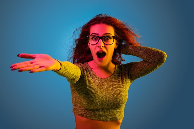 Caucasian woman's portrait isolated on blue  space in neon light