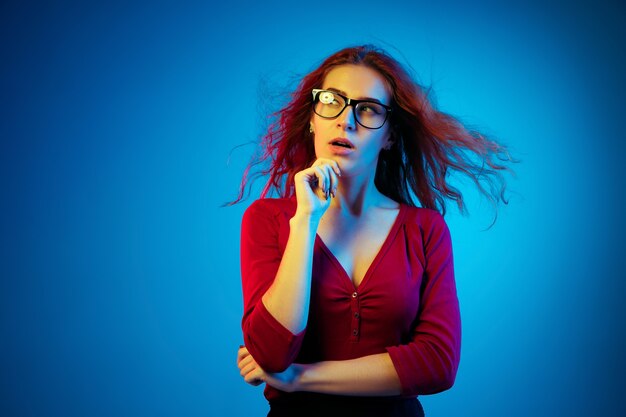 Caucasian woman's portrait isolated on blue  space in neon light