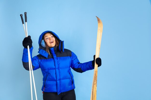 Caucasian woman's portrait isolated on blue studio background, winter theme