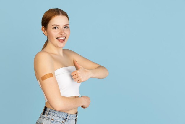 Caucasian woman's portrait isolated over blue studio background with copyspace for ad Concept of beauty health