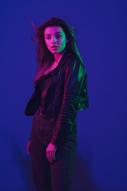 Caucasian woman's portrait isolated on blue studio in neon light