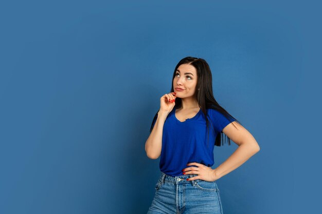 Caucasian woman's portrait isolated on blue studio wall