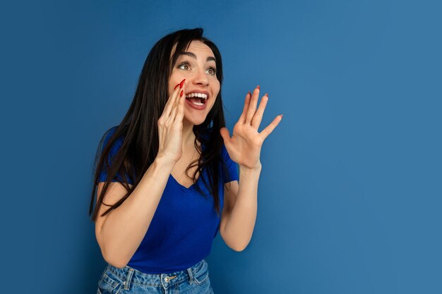 Caucasian woman's portrait isolated on blue studio wall