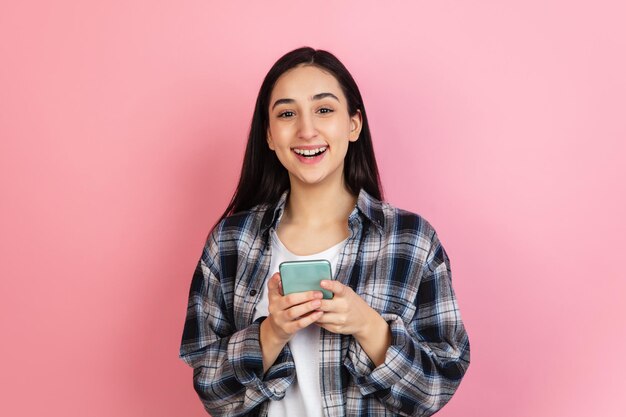 コピースペースとコーラルピンクのスタジオの背景に分離された白人女性の肖像画