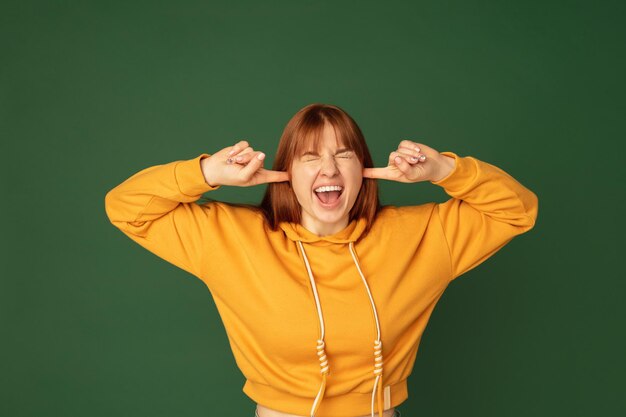 Caucasian woman's portrait isolated on green studio background with copyspace