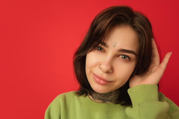 Портрет кавказской женщины изолирован на красном фоне студии с копирайтом