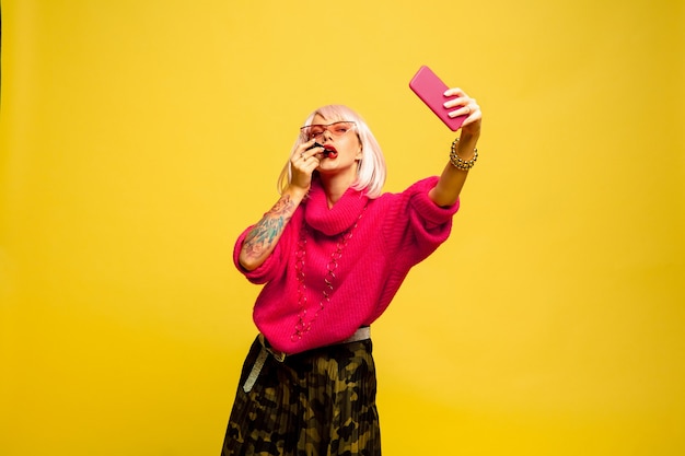 Caucasian woman's portrait on yellow background. Beautiful blonde model. Concept of human emotions, facial expression,