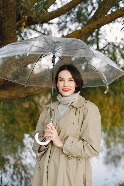 Caucasian woman standing outdoors and posing with transparent umbrella