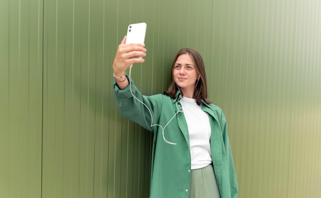 Caucasian woman taking a selfie with her smartphone