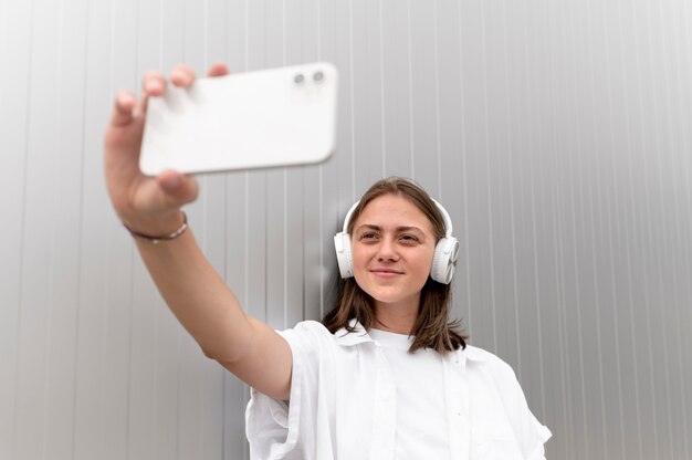 Foto gratuita donna caucasica che si fa un selfie con il suo smartphone