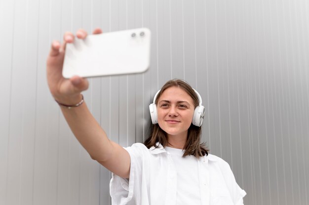 Caucasian woman taking a selfie with her smartphone