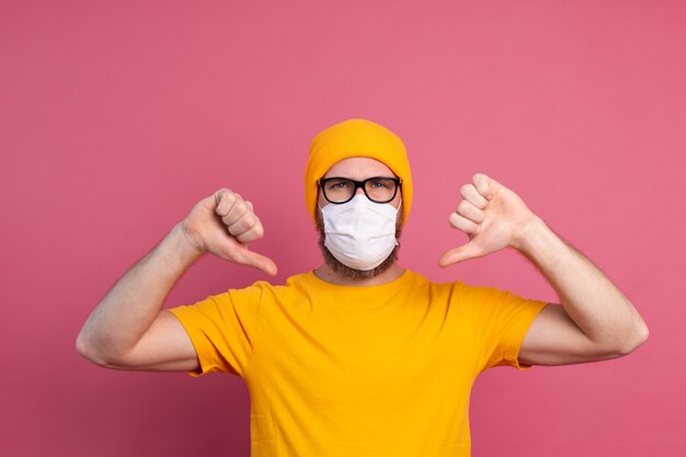感染症、インフルエンザなどの呼吸器疾患を防ぐために単回使用医療マスクと眼鏡をかけた白人の若い男