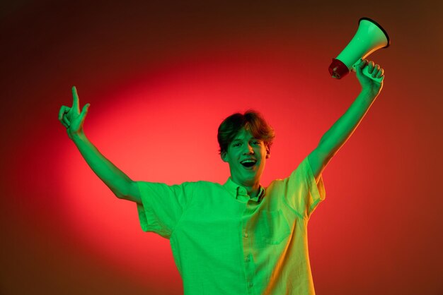 Caucasian young man isolated on blue studio background in neon Concept of human emotions facial expression