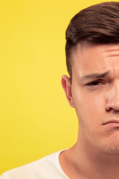 Caucasian young man's close up portrait on yellow