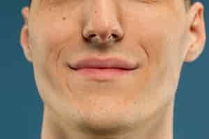 Free photo caucasian young man's close up shot on blue wall
