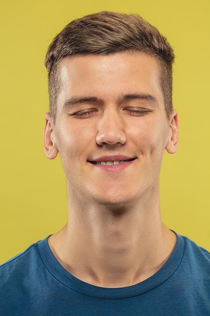 Caucasian young man's close up on yellow studio