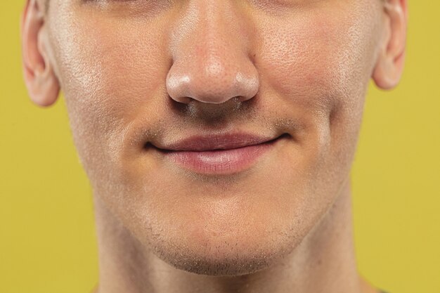 Caucasian young man's close up on yellow studio