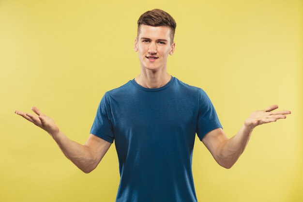 Caucasian young man's half-length portrait  Beautiful male model in blue shirt. Concept of human emotions, facial expression