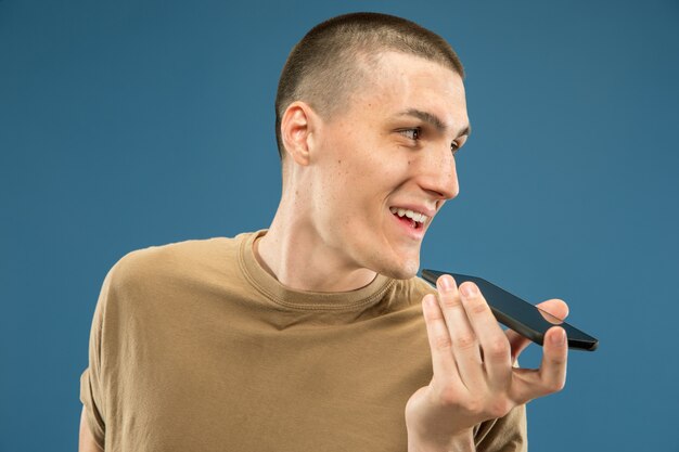 Caucasian young man's half-length portrait on blue studio