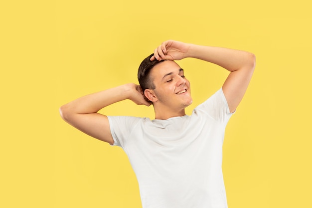 Caucasian young man's half-length portrait on yellow studio