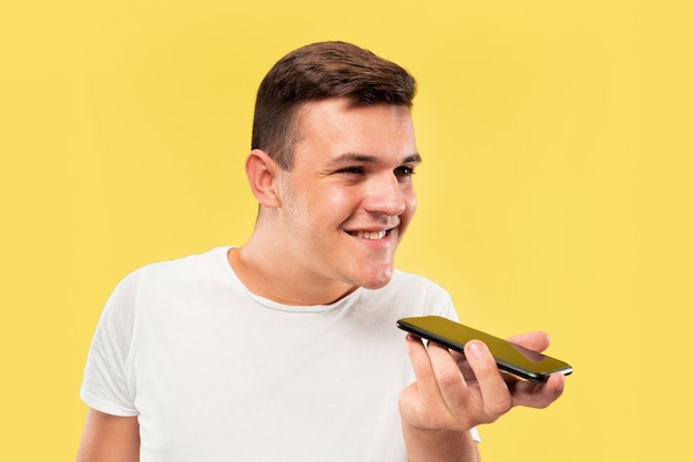 Caucasian young man's half-length portrait on yellow studio