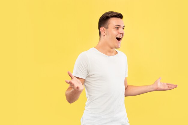 Caucasian young man's half-length portrait on yellow studio