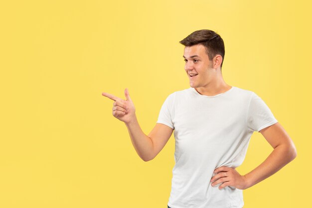 Caucasian young man's half-length portrait on yellow studio