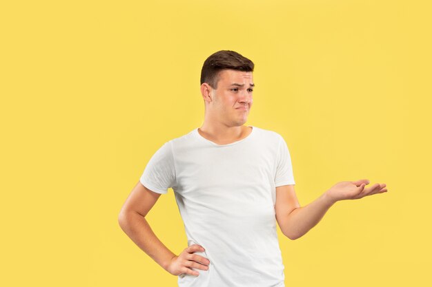 Caucasian young man's half-length portrait on yellow studio