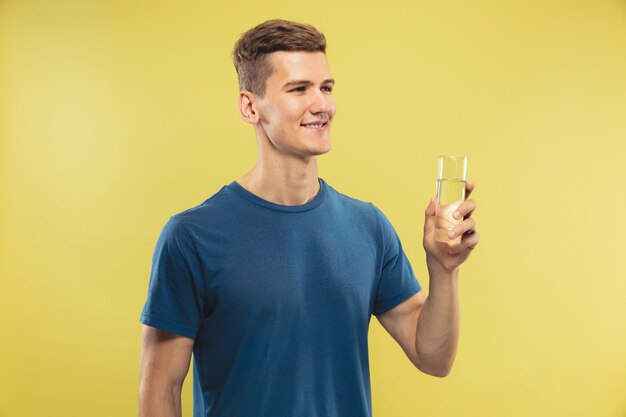 Free photo caucasian young man's half-length portrait on yellow studio