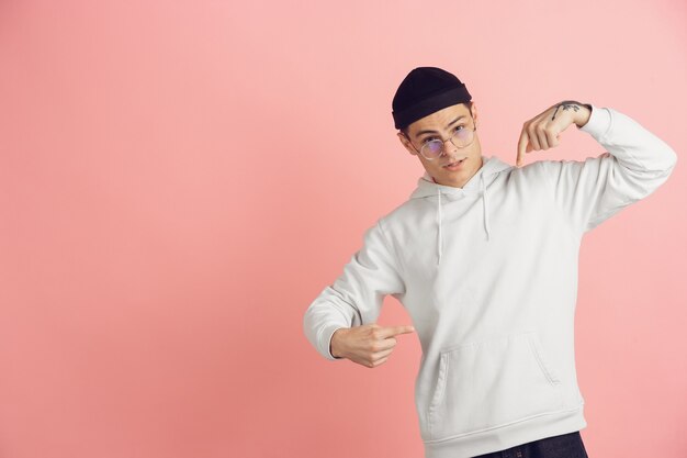 Caucasian young man's modern portrait on pink studio