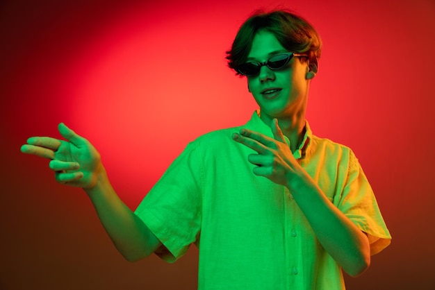 Caucasian young man's portrait on dark studio background in neon Concept of human emotions facial expression