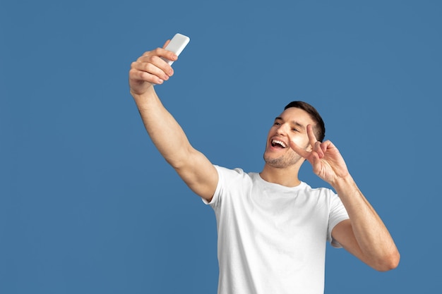 Free photo caucasian young man's portrait isolated on blue  background.