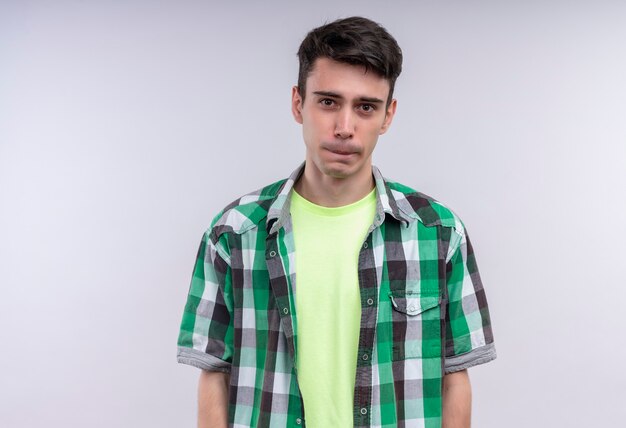 caucasian young man wearing green shirt on isolated white wall