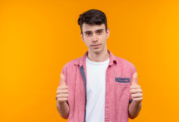 caucasian young man wearing pink shirt his thumbs up on isolated orange wall