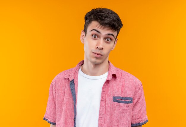 caucasian young man wearing pink shirt on isolated orange wall