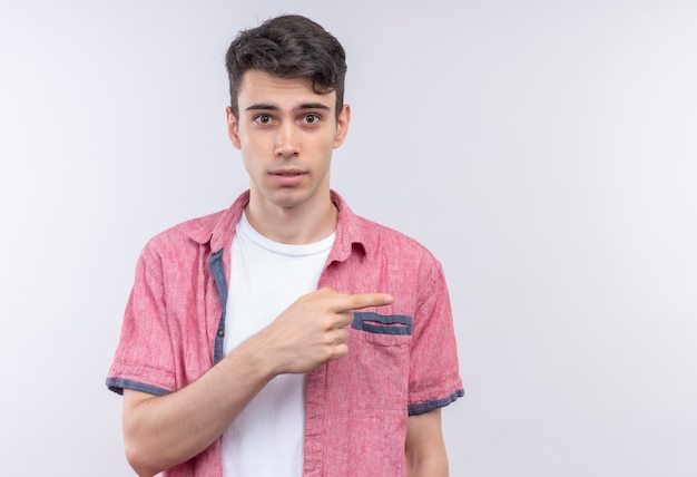 Foto gratuita il giovane caucasico che indossa la camicia rosa punta a lato sul muro bianco isolato