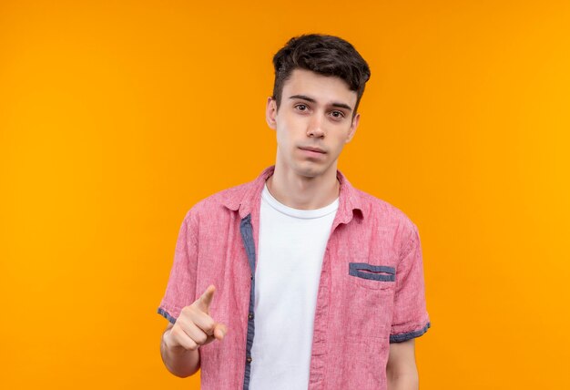 孤立したオレンジ色の壁にジェスチャーを示すピンクのシャツを着ている白人の若い男
