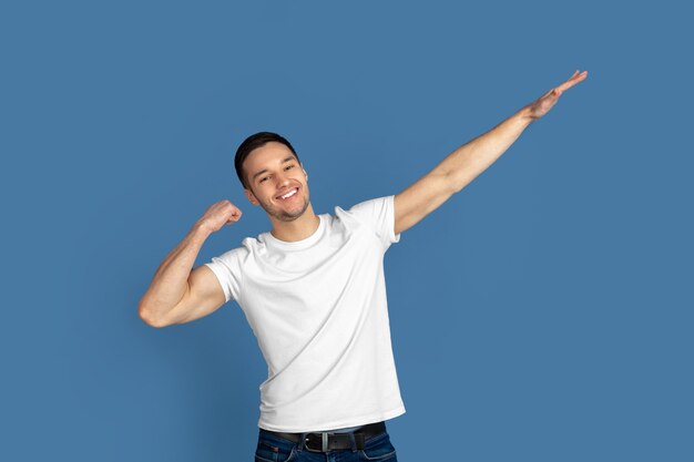 Caucasian young mans portrait on blue  surface