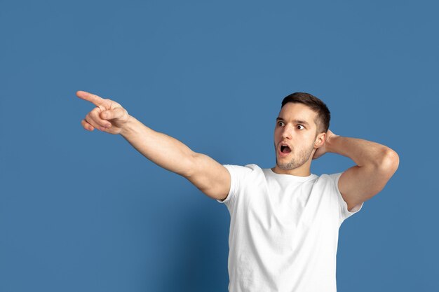 Caucasian young mans portrait on blue  surface