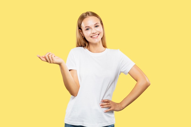 Free photo caucasian young woman's half-length portrait on yellow studio