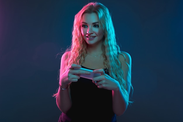Caucasian young woman's portrait on gradient in neon light