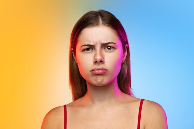 Caucasian young woman's portrait on gradient in neon