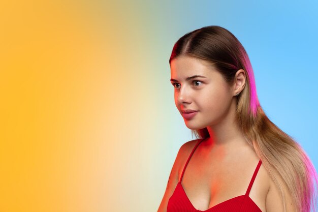 Caucasian young woman's portrait on gradient in neon