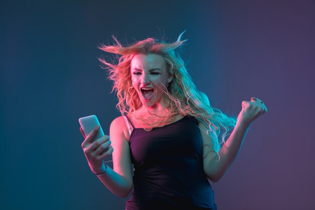 Caucasian young woman's portrait on gradient space in neon light. Beautiful female model with unusual look