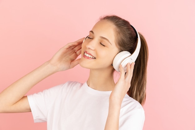 Caucasian young woman's portrait isolated on pink studio wall with copyspace.